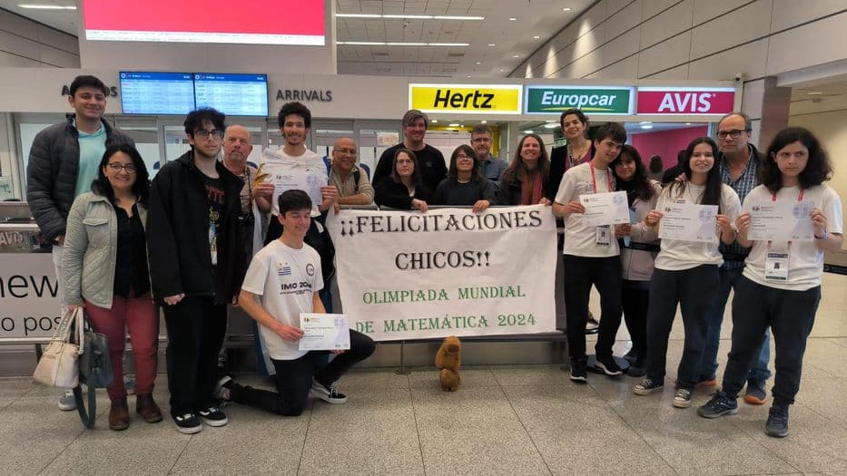 Estudiantes uruguayos con la bandera nacional celebrando sus logros en las olimpiadas matemáticas